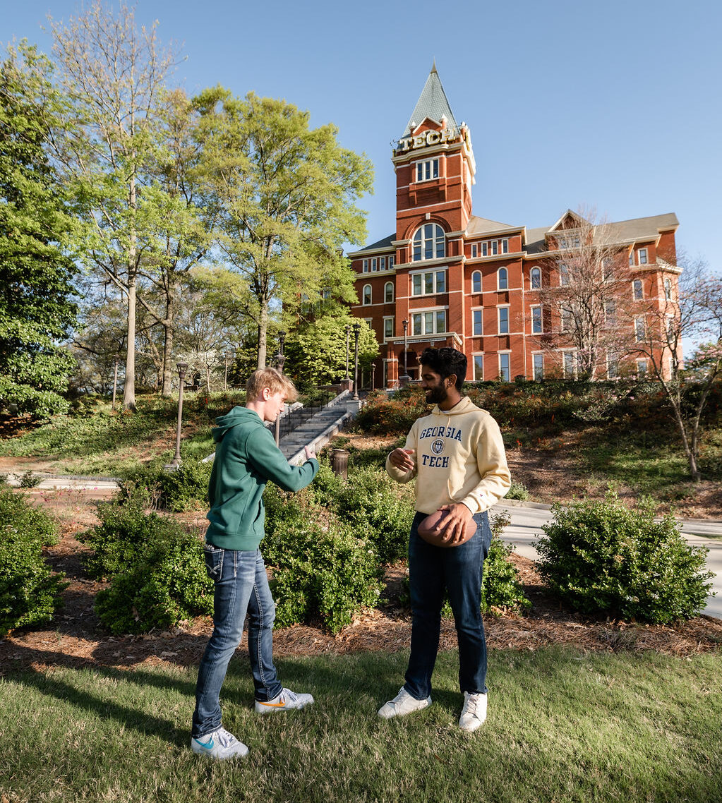 Students playing with a football on Georgia Tech's campus.