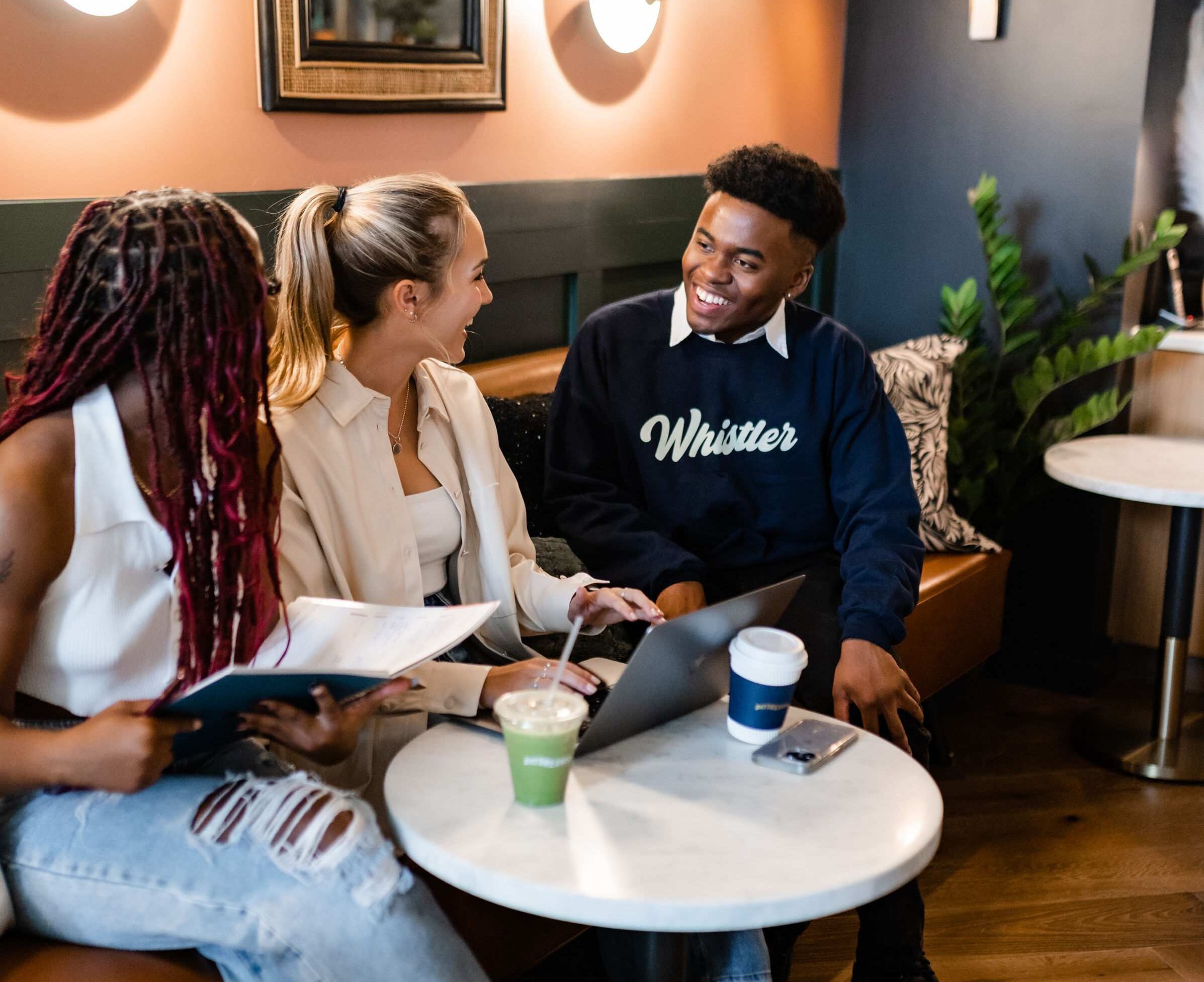 an employee at whistler, a new student apartment in midtown atlanta, helps two students with questions about apartment costs