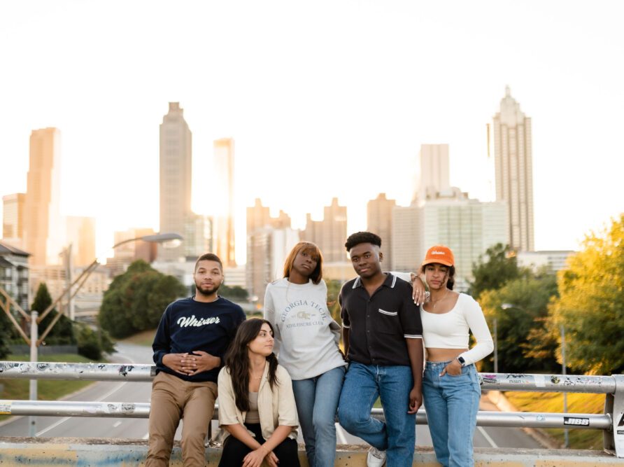 Friends posing on a bridge with the Atlanta skyline in the background