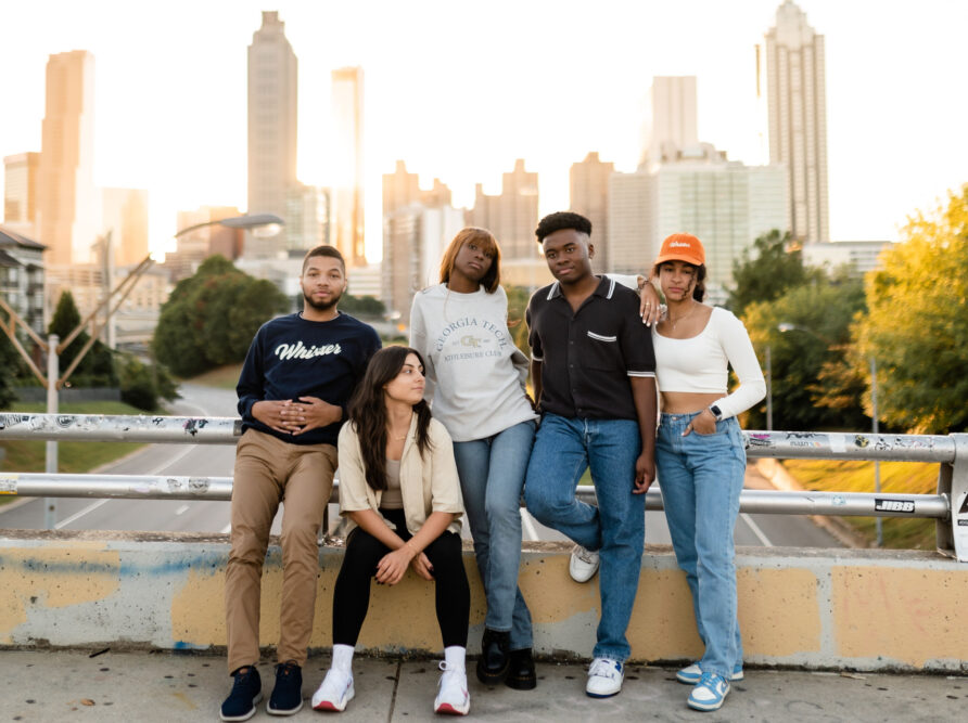 Georgia Tech students posing on a bridge with the Atlanta skyline in the background